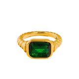 Gold ring with a green gemstone on a white background