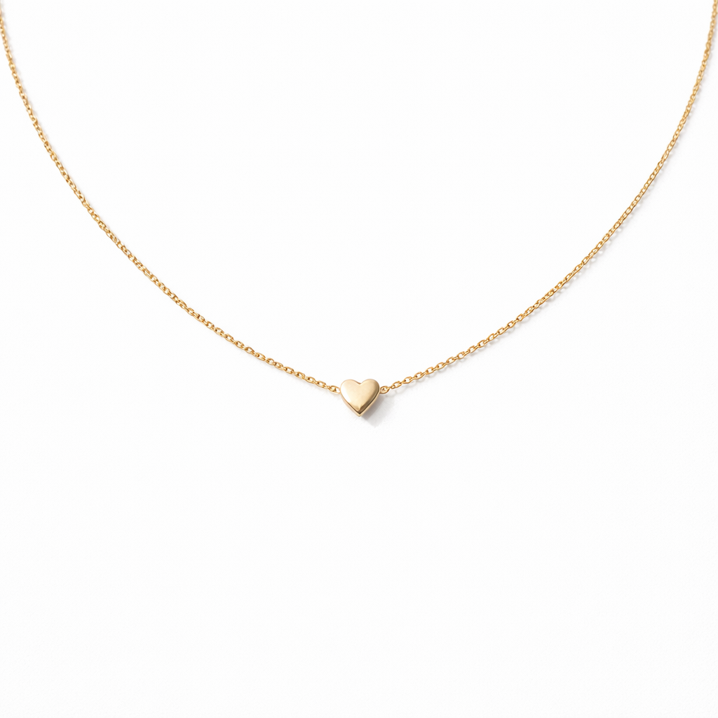 Gold heart-shaped pendant necklace on a white background