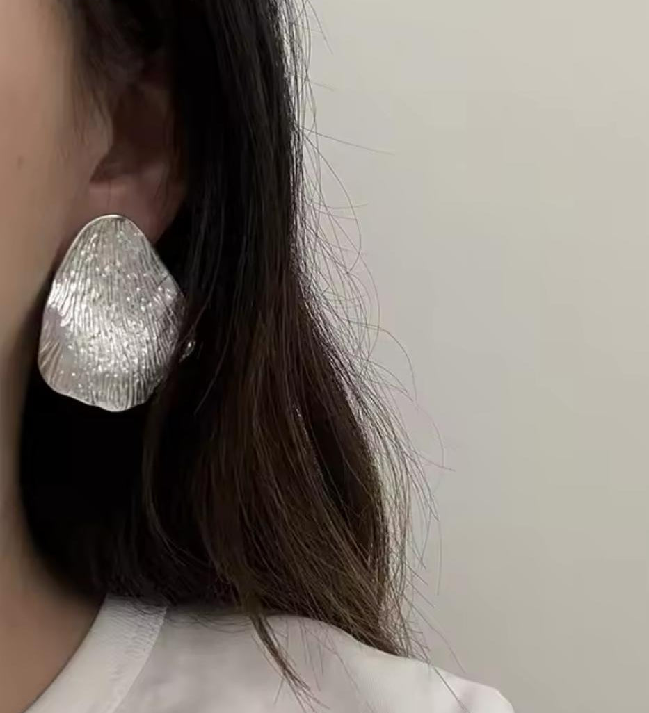 Bold sculptural statement earrings crafted from a durable brass base with sterling silver plating. Featuring a distinctive, modern silhouette, these hypoallergenic, water- and tarnish-resistant earrings add polished personality to everyday looks or special occasions.