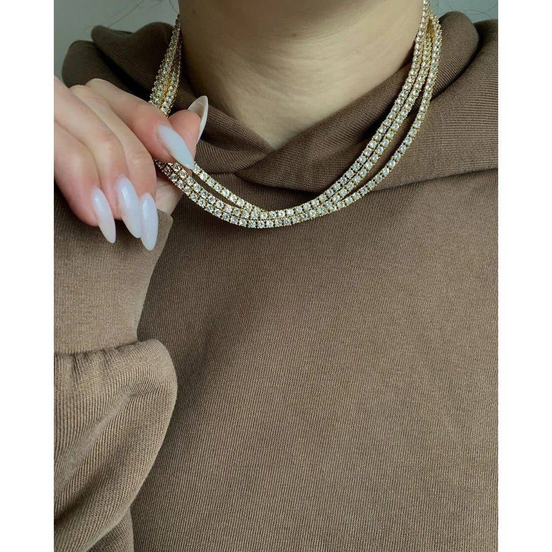Classic tennis necklace crafted from brass with premium 18K gold plating, featuring brilliant cubic zirconia for timeless sparkle. Hypoallergenic, water- and tarnish-resistant—perfect for wearing solo or layered to add effortless sophistication to any look.
