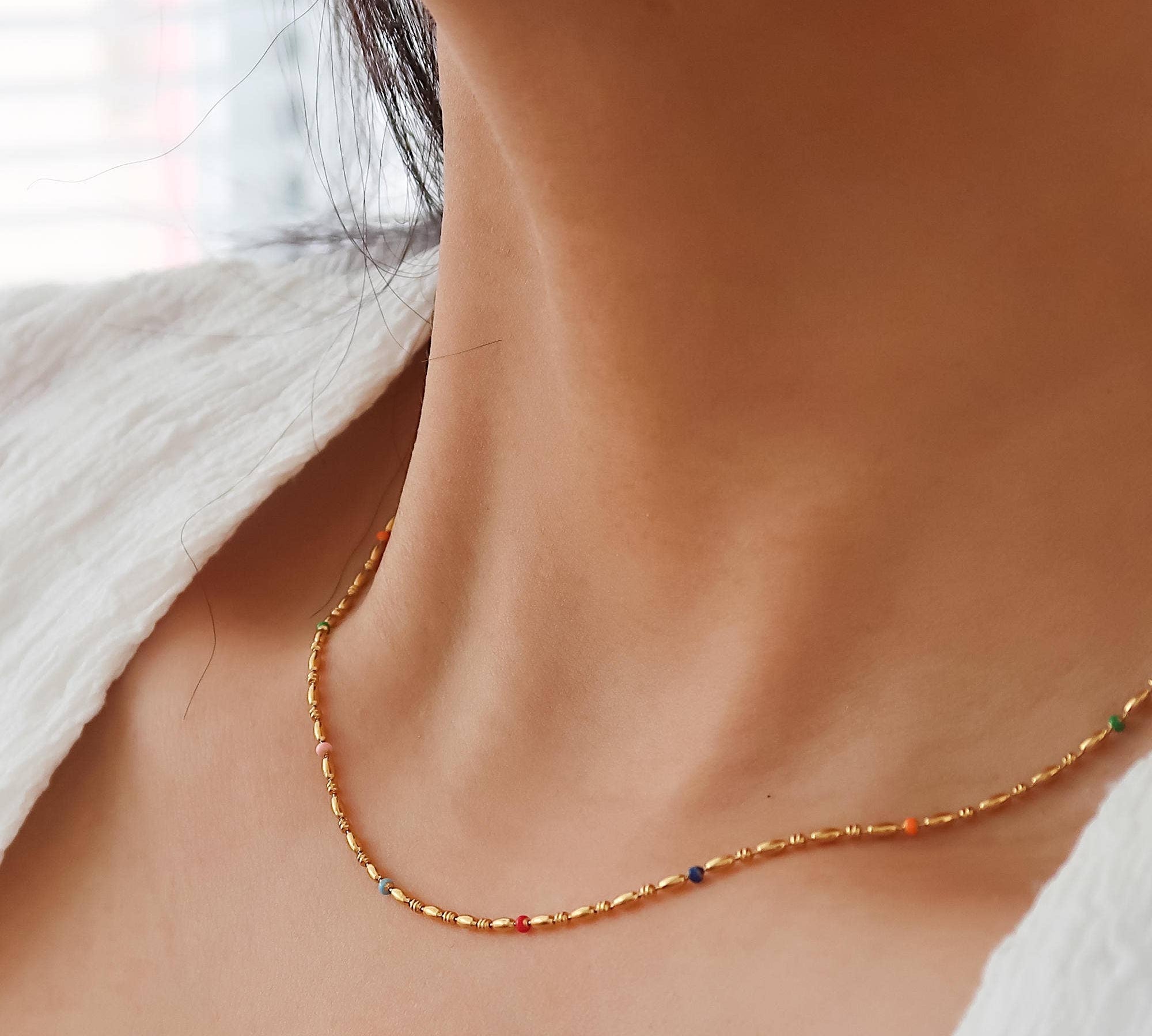 Delicate necklace crafted from stainless steel with 18K gold plating, featuring petite beaded detailing for subtle texture. Chain length 15 inches plus 2-inch extension. Minimalist and versatile—perfect for adding understated charm to any everyday look. Hypoallergenic, water- and tarnish-resistant.