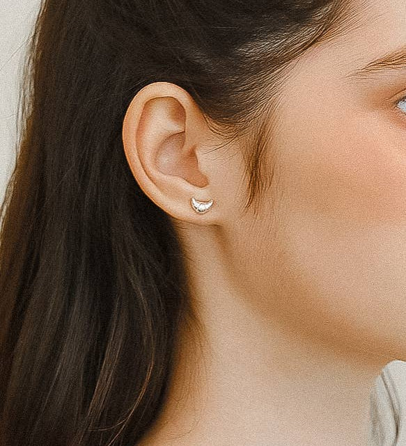 Petite sculptural stud earrings crafted from a brass base with premium 18K gold or silver plating, featuring a modern croissant-inspired design. Minimalist and Parisian-chic—perfect for adding a stylish twist to any everyday look. Hypoallergenic, water- and tarnish-resistant.