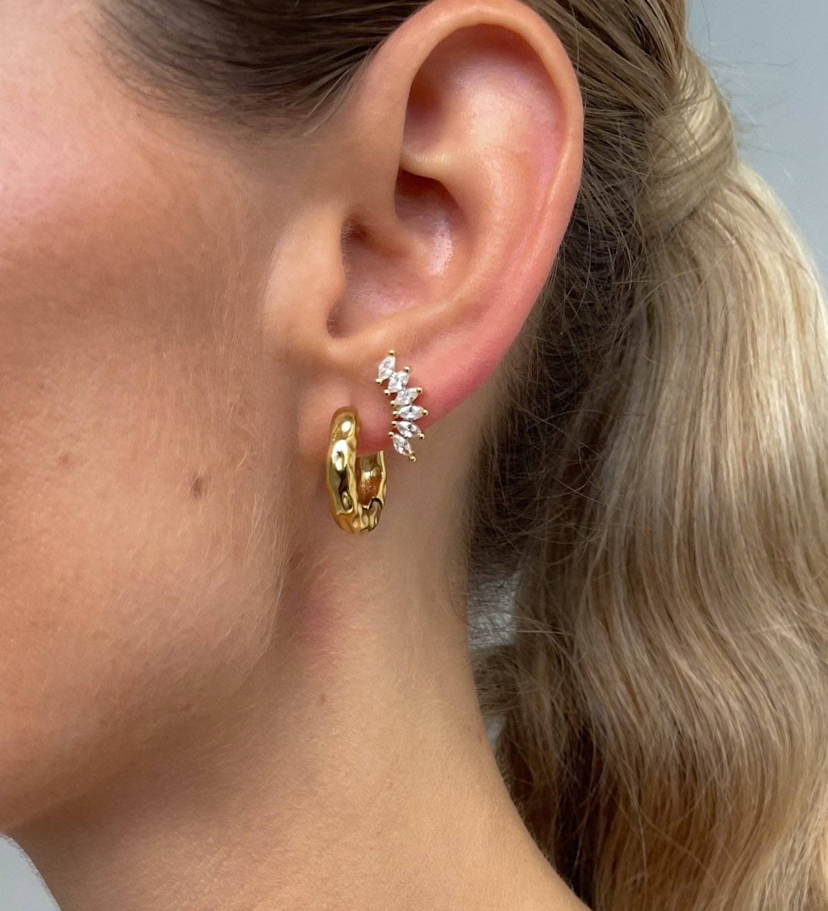 Ear climber stud crafted from 18K gold PVD-plated stainless steel, featuring six marquise-cut crystals for refined, elegant sparkle. Hypoallergenic, water- and tarnish-resistant—perfect for adding a modern, timeless touch to any ear stack.
