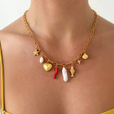Delicate gold necklace featuring playful ocean-inspired charms—a fish and a pearl—on an 18K gold-plated stainless steel chain. Pendant measures 0.5 to 1.1 inches; chain is 17.7 inches with a 2-inch extender. Hypoallergenic, water- and tarnish-resistant—perfect worn solo or layered for a whimsical touch.