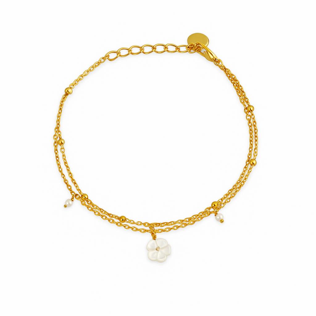 Gold bracelet with pearl charms on a white background