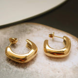 Gold hoop earrings on a textured surface