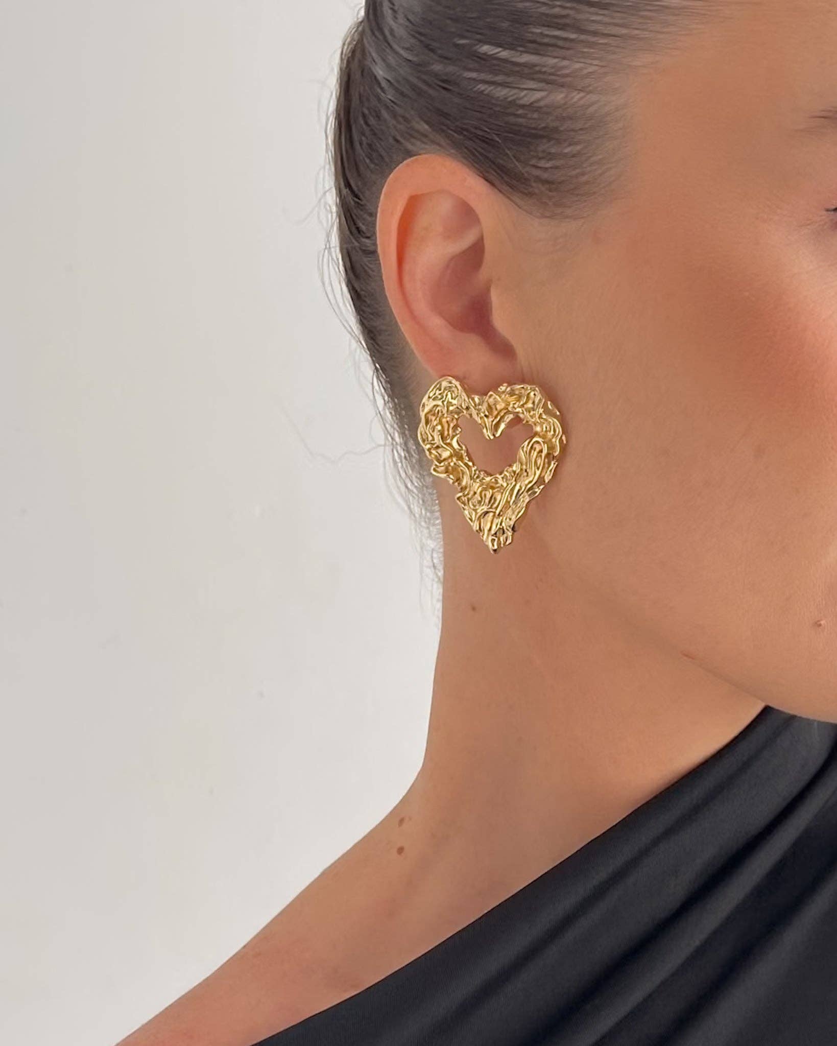 Sculpted heart stud earrings crafted from 18K gold PVD-plated stainless steel, featuring a unique textured design for added dimension and charm. Hypoallergenic, water- and tarnish-resistant—perfect for making a bold, romantic statement.