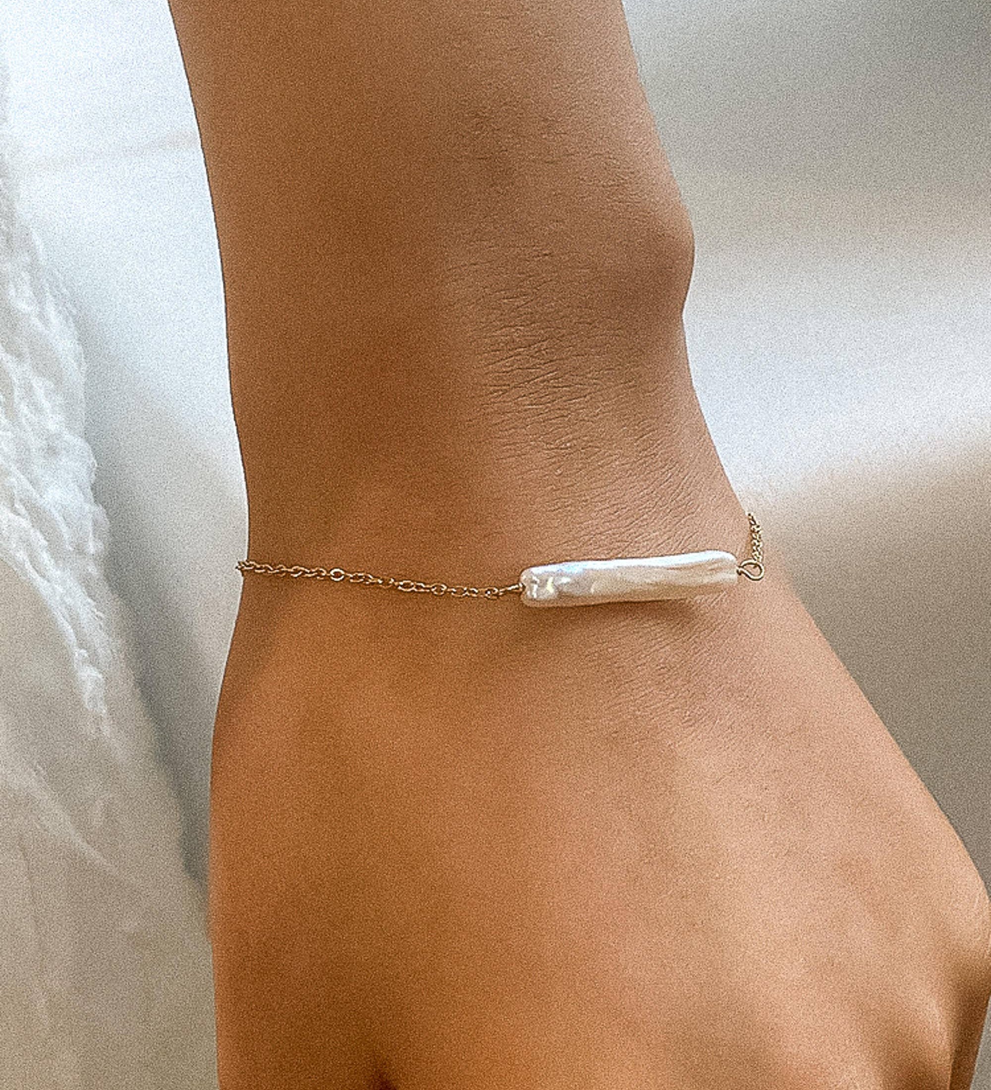 Elegant 18K gold-plated bracelet featuring a lustrous freshwater pearl pendant (1.22 inches) on a 6.69-inch stainless steel chain with a 1.96-inch extender. Non-tarnish, hypoallergenic, water-resistant, and free from lead and nickel—perfect for refined, everyday luxury or meaningful gifting.