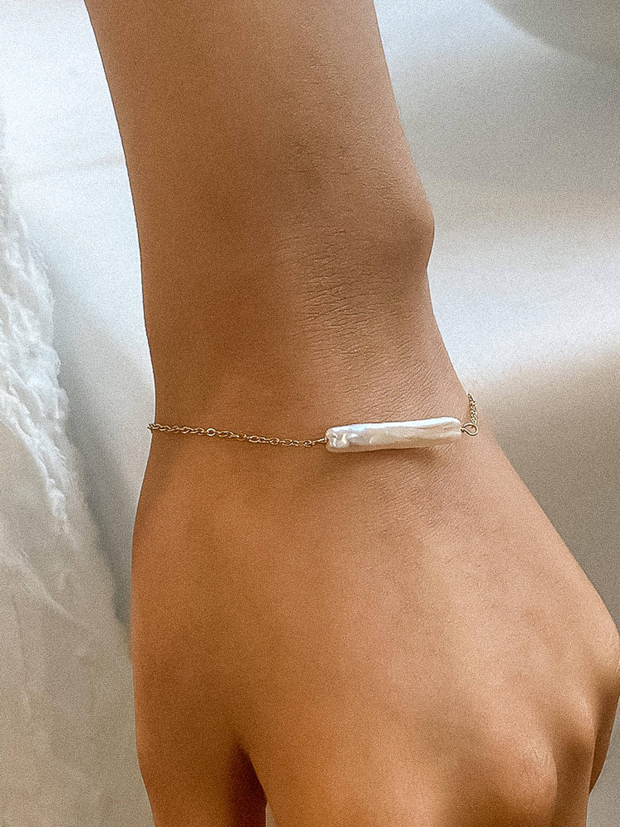 Elegant 18K gold-plated bracelet featuring a lustrous freshwater pearl pendant (1.22 inches) on a 6.69-inch stainless steel chain with a 1.96-inch extender. Non-tarnish, hypoallergenic, water-resistant, and free from lead and nickel—perfect for refined, everyday luxury or meaningful gifting.