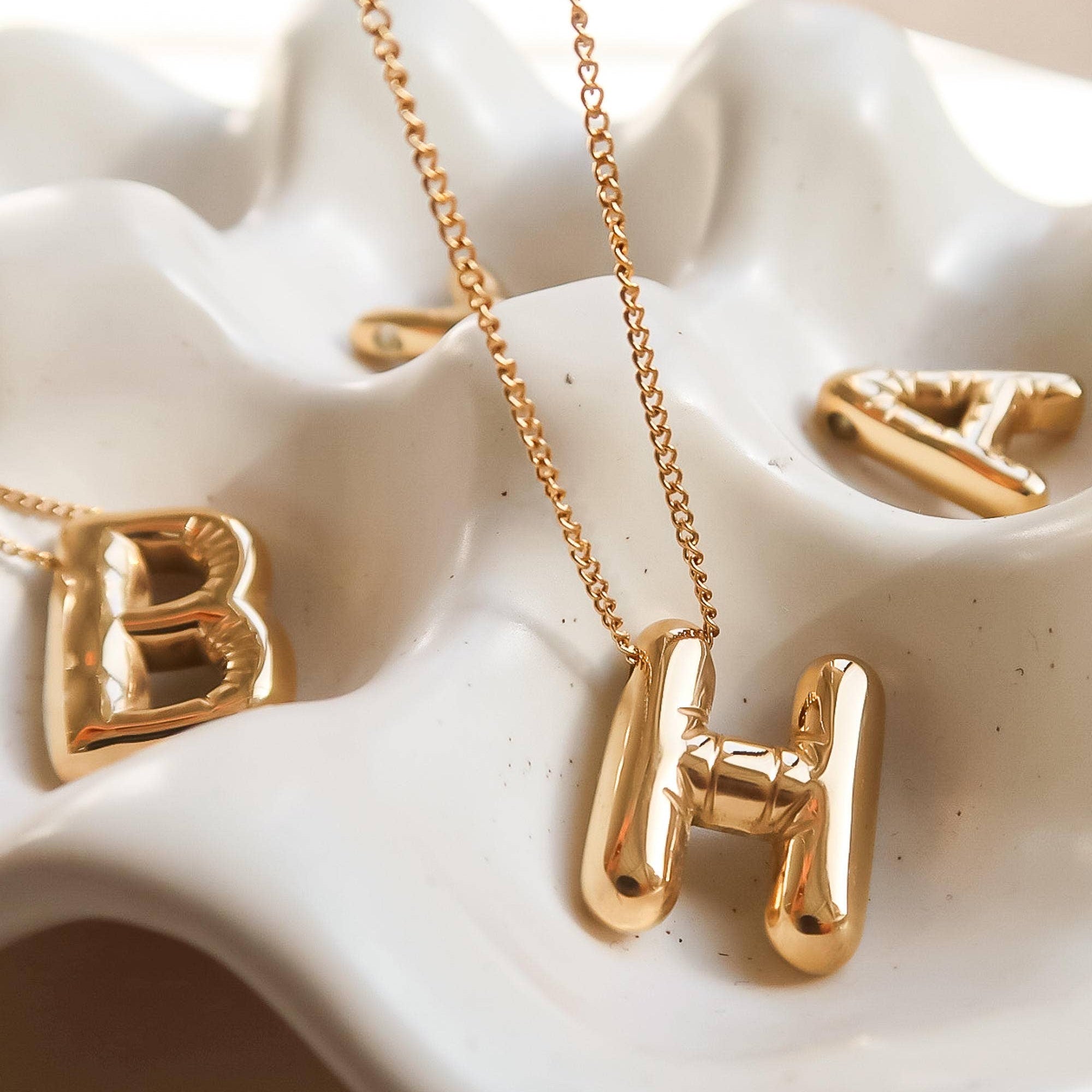 Playful necklace crafted from premium stainless steel with 18K gold plating, featuring a balloon-style alphabet letter pendant (0.8 inch). Chain length 16 inches plus 2-inch extender. Hypoallergenic, water- and tarnish-resistant—perfect for adding a personal and whimsical touch to any look