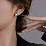 Mini droplet huggie earrings crafted from stainless steel with elegant 18K gold plating. Subtle yet eye-catching 20mm length adds a touch of glamour and sophistication. Hypoallergenic, water- and tarnish-resistant—perfect for elevating any outfit with refined shine.