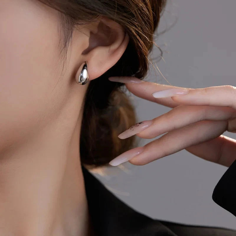 Mini droplet huggie earrings crafted from stainless steel with elegant 18K gold plating. Subtle yet eye-catching 20mm length adds a touch of glamour and sophistication. Hypoallergenic, water- and tarnish-resistant—perfect for elevating any outfit with refined shine.