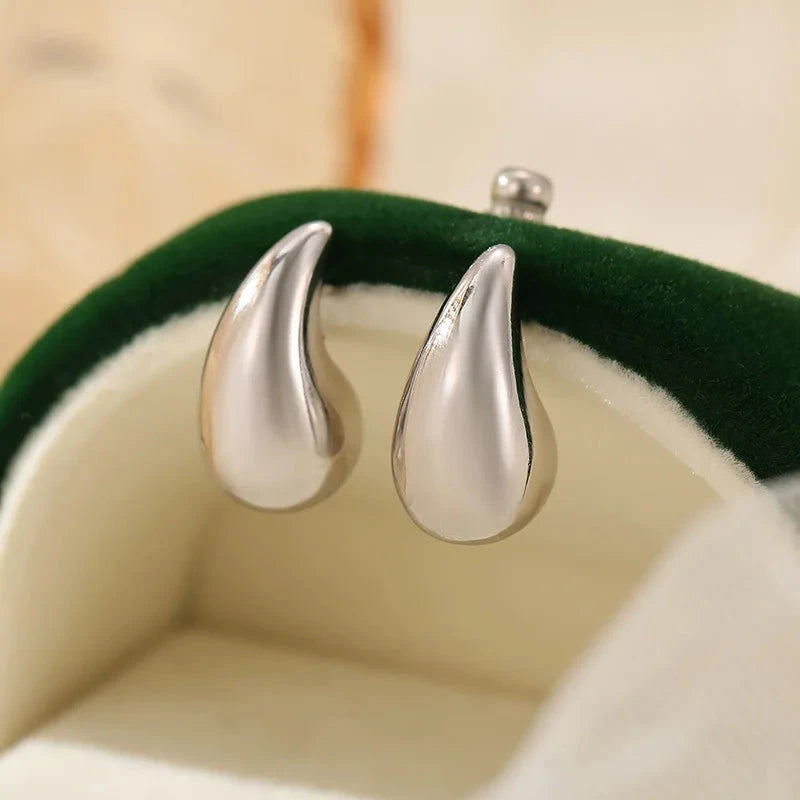 Mini droplet huggie earrings crafted from stainless steel with elegant 18K gold plating. Subtle yet eye-catching 20mm length adds a touch of glamour and sophistication. Hypoallergenic, water- and tarnish-resistant—perfect for elevating any outfit with refined shine.