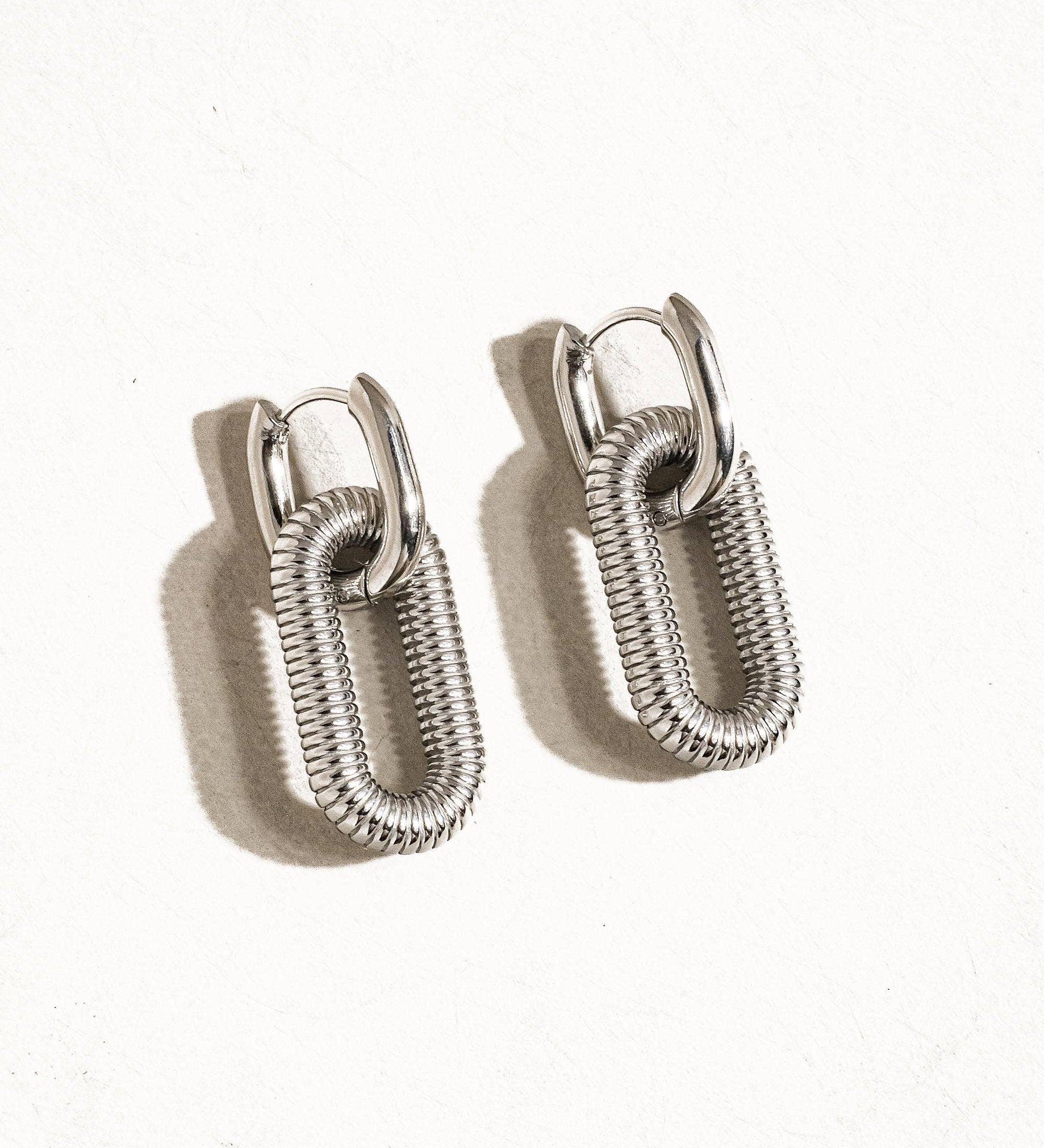 Modern hoop earrings crafted from stainless steel with your choice of 18K gold or silver plating, featuring a double chain detail for added edge and sophistication. Hypoallergenic, water- and tarnish-resistant—perfect for making a bold yet refined statement in any jewellery rotation.