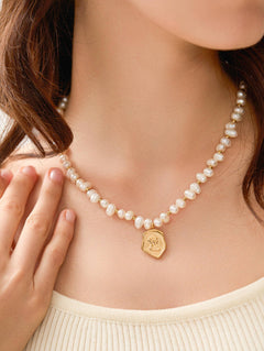 Necklace crafted from a brass base with premium 18K gold plating, featuring natural freshwater pearls and a sculptural abstract coin pendant. Hypoallergenic, water- and tarnish-resistant—perfect for adding Parisian charm and vintage-inspired elegance with a modern touch.