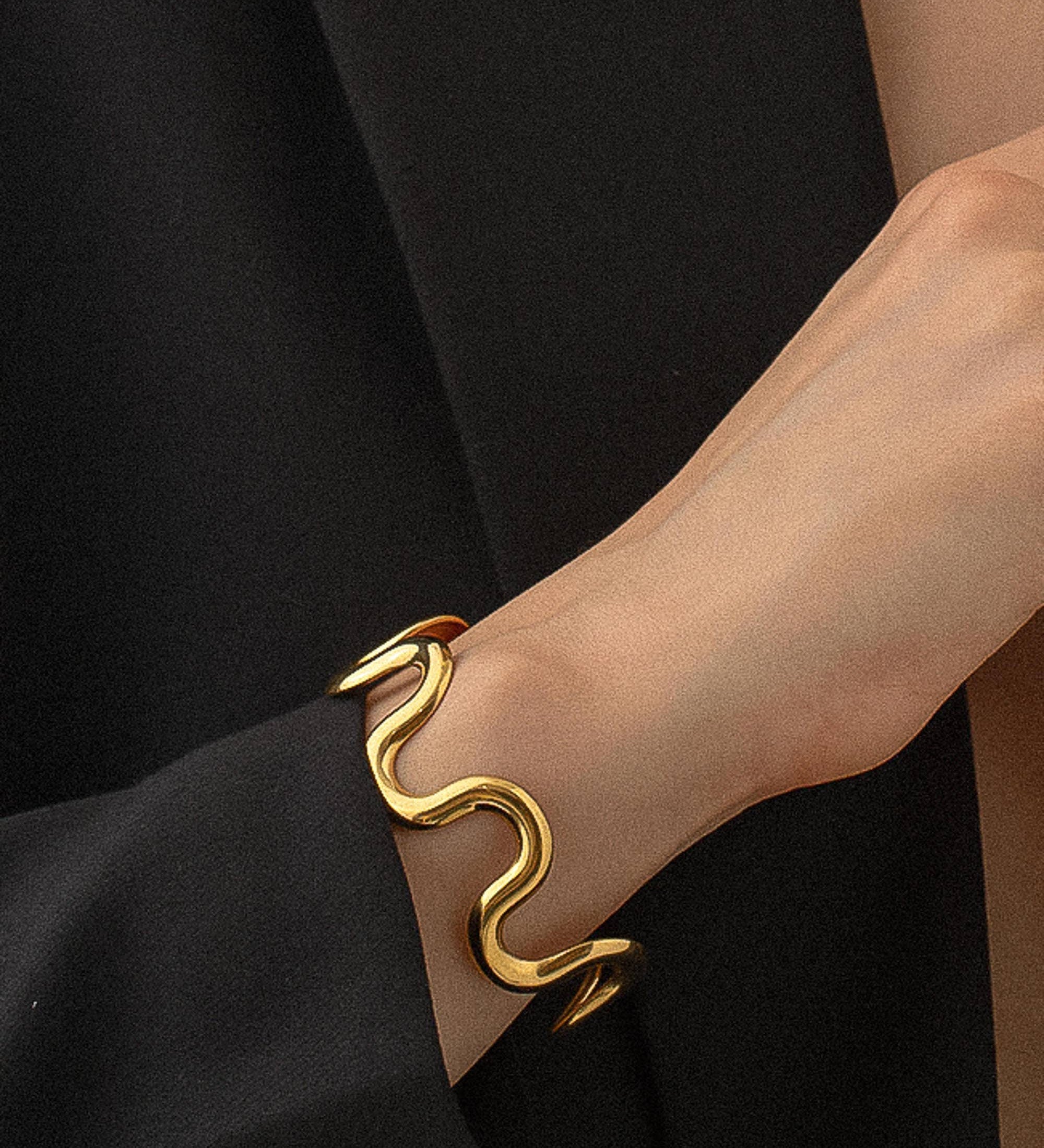 Sculptural statement cuff bracelet crafted from 18K gold-plated stainless steel, featuring a bold, organic wavy silhouette for modern elegance. Hypoallergenic, water- and tarnish-resistant—perfect for adding effortlessly chic style to any outfit.