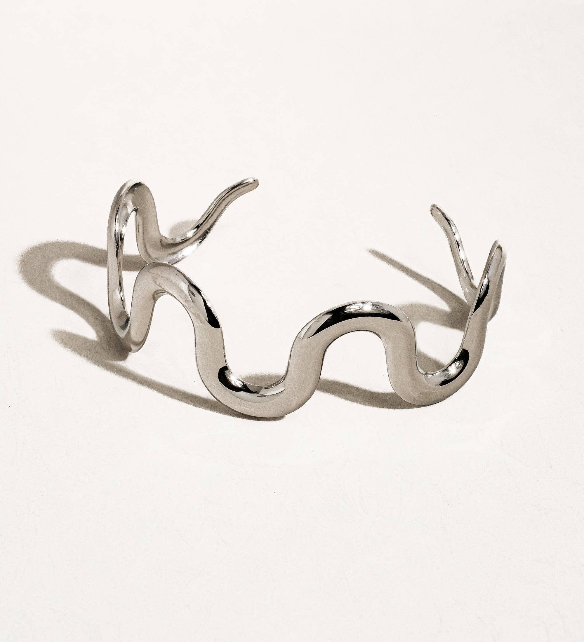 Sculptural statement cuff bracelet crafted from 18K gold-plated stainless steel, featuring a bold, organic wavy silhouette for modern elegance. Hypoallergenic, water- and tarnish-resistant—perfect for adding effortlessly chic style to any outfit.