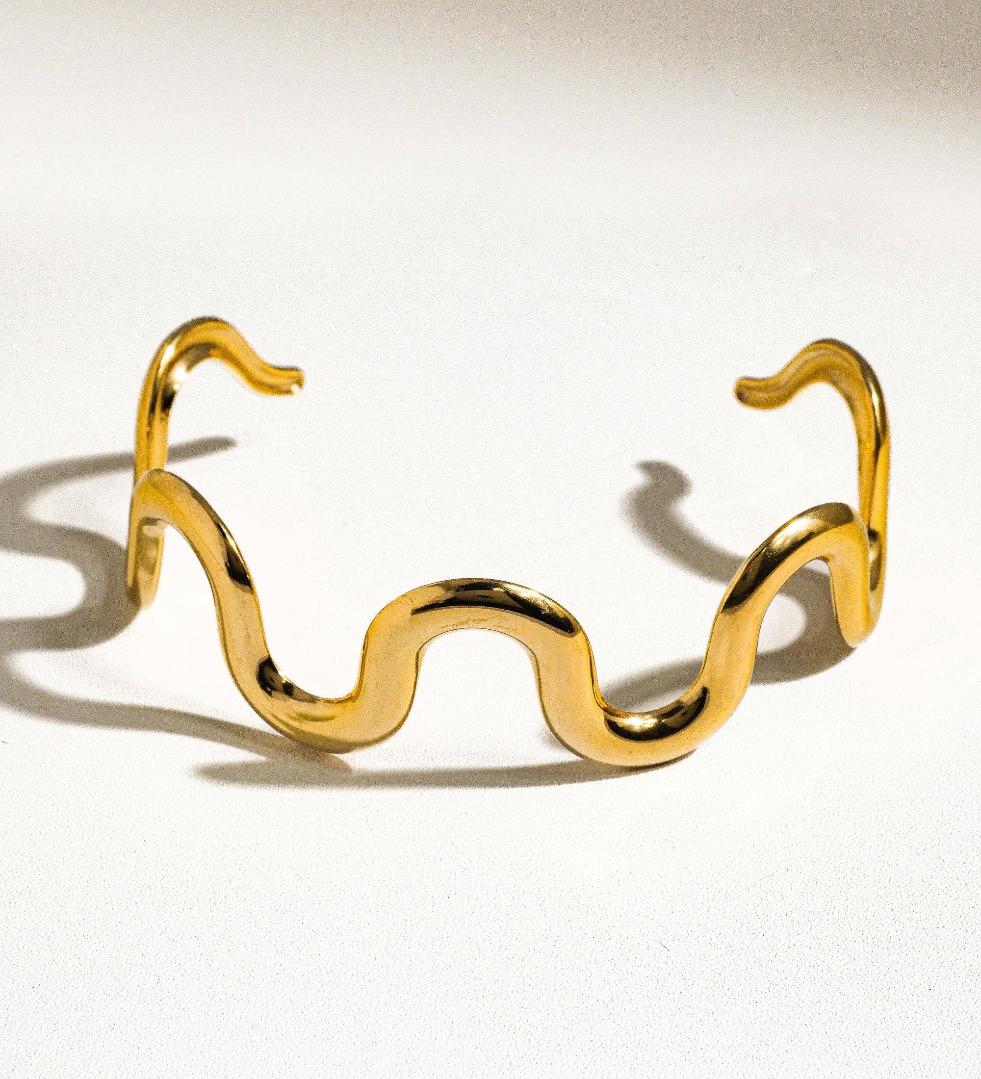 Sculptural statement cuff bracelet crafted from 18K gold-plated stainless steel, featuring a bold, organic wavy silhouette for modern elegance. Hypoallergenic, water- and tarnish-resistant—perfect for adding effortlessly chic style to any outfit.