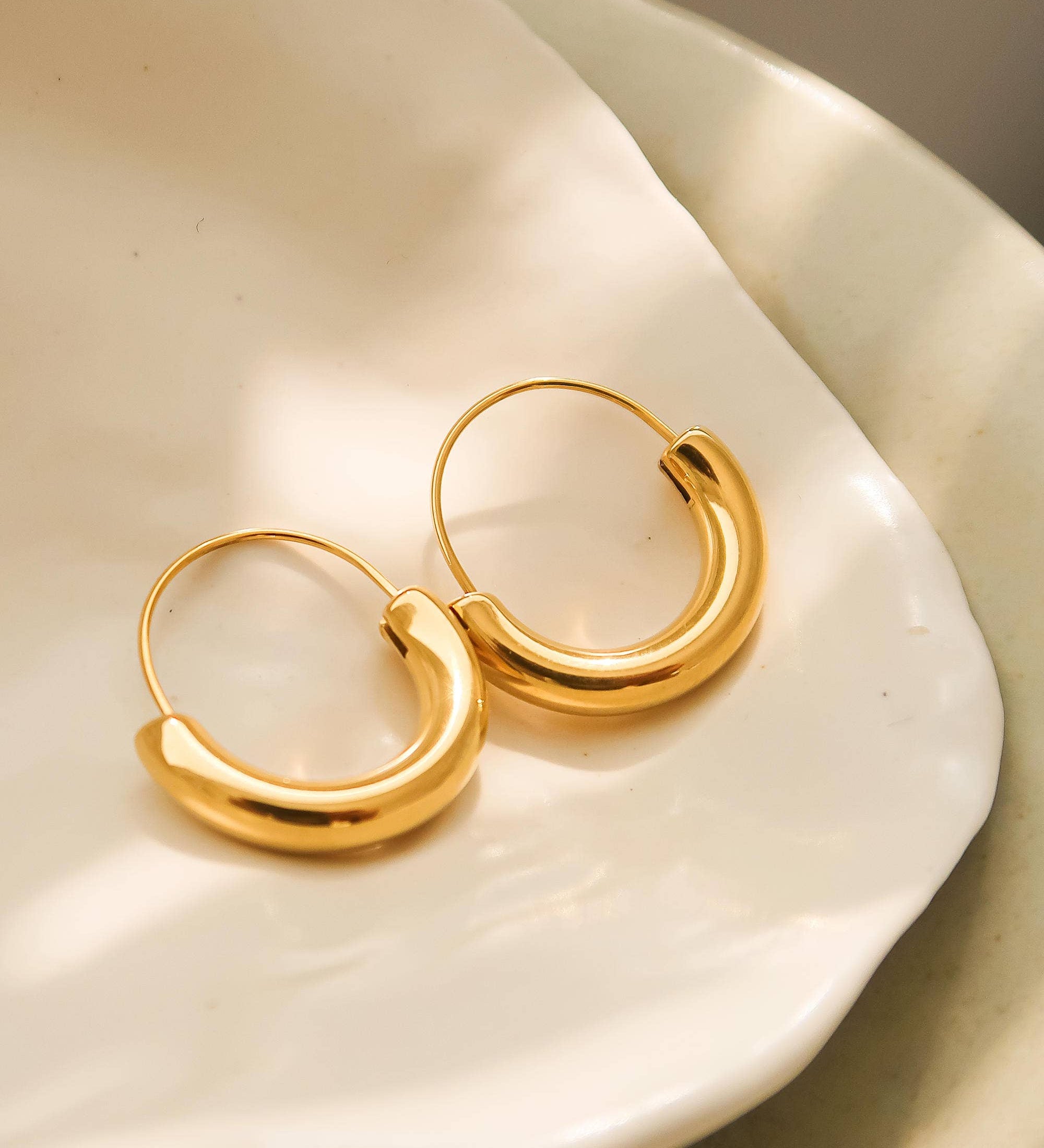 Sleek U-shaped hoop earrings with a softly polished finish, crafted for a modern twist on a timeless silhouette. Made from hypoallergenic, water- and tarnish-resistant materials—perfect for adding effortless sophistication to both casual and dressy looks.