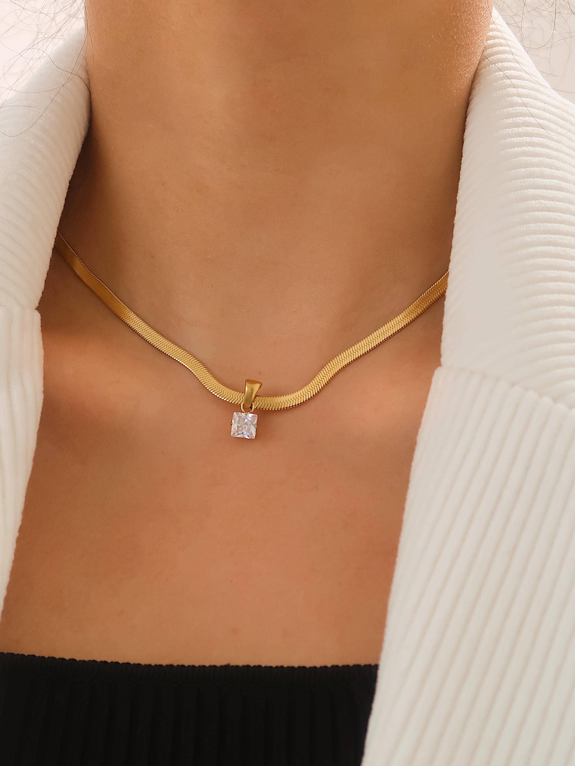 Sleek snake chain necklace crafted from premium stainless steel with 18K gold plating, featuring a square-cut cubic zirconia pendant (0.25” / 0.64cm) for refined sparkle. Hypoallergenic, water- and tarnish-resistant—perfect for effortless, modern elegance.