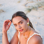 Woman sitting on a sandy beach with a blurred natural background