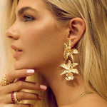 Statement earrings crafted from stainless steel with premium 18K gold plating, featuring a bold sculpted flower motif. Hypoallergenic, nickel-free, water- and tarnish-resistant—perfect for adding floral elegance and standout charm to any outfit.