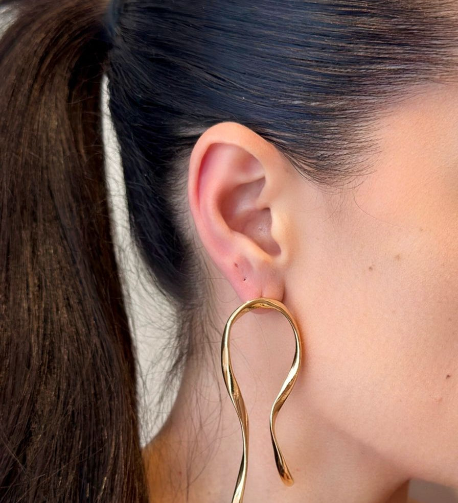 Statement hoop earrings crafted from 18K gold-plated stainless steel, featuring a unique curved organic shape for refined, edgy appeal. Hypoallergenic, water- and tarnish-resistant—perfect for elevating any outfit from day to night with bold elegance.