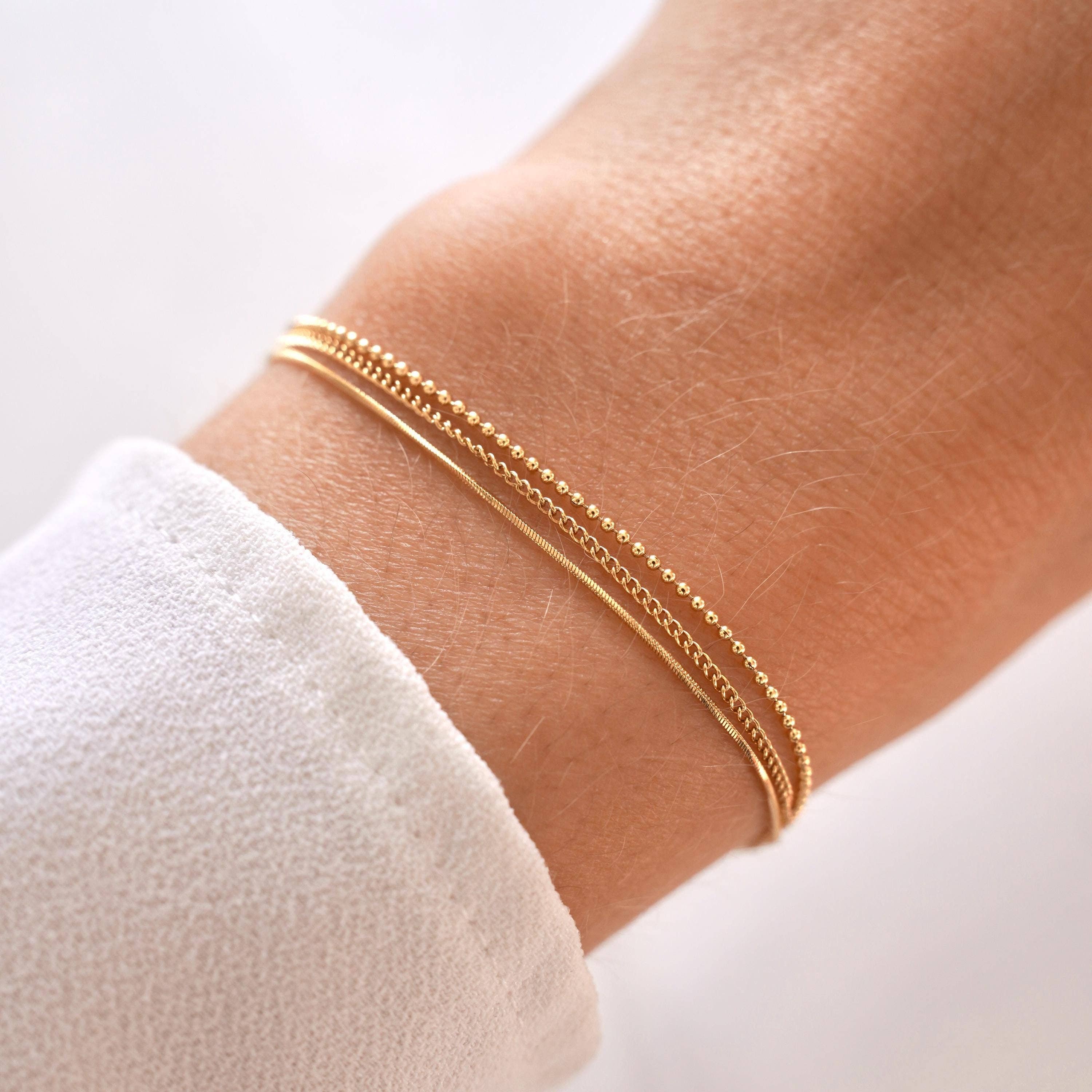Elegant women's bracelet featuring three fine stainless steel chains with a 15.5 cm base length and 3 cm adjustable extender for a perfect wrist fit. Ideal for layering with other gold bracelets and makes a thoughtful gift. Packaged in a small jewellery pouch.