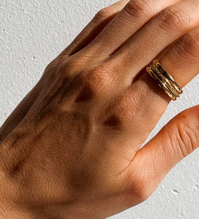 Three Sisters Stacking Ring Set features a trio of sleek & textured 18K gold-plated rings. Waterproof, hypoallergenic