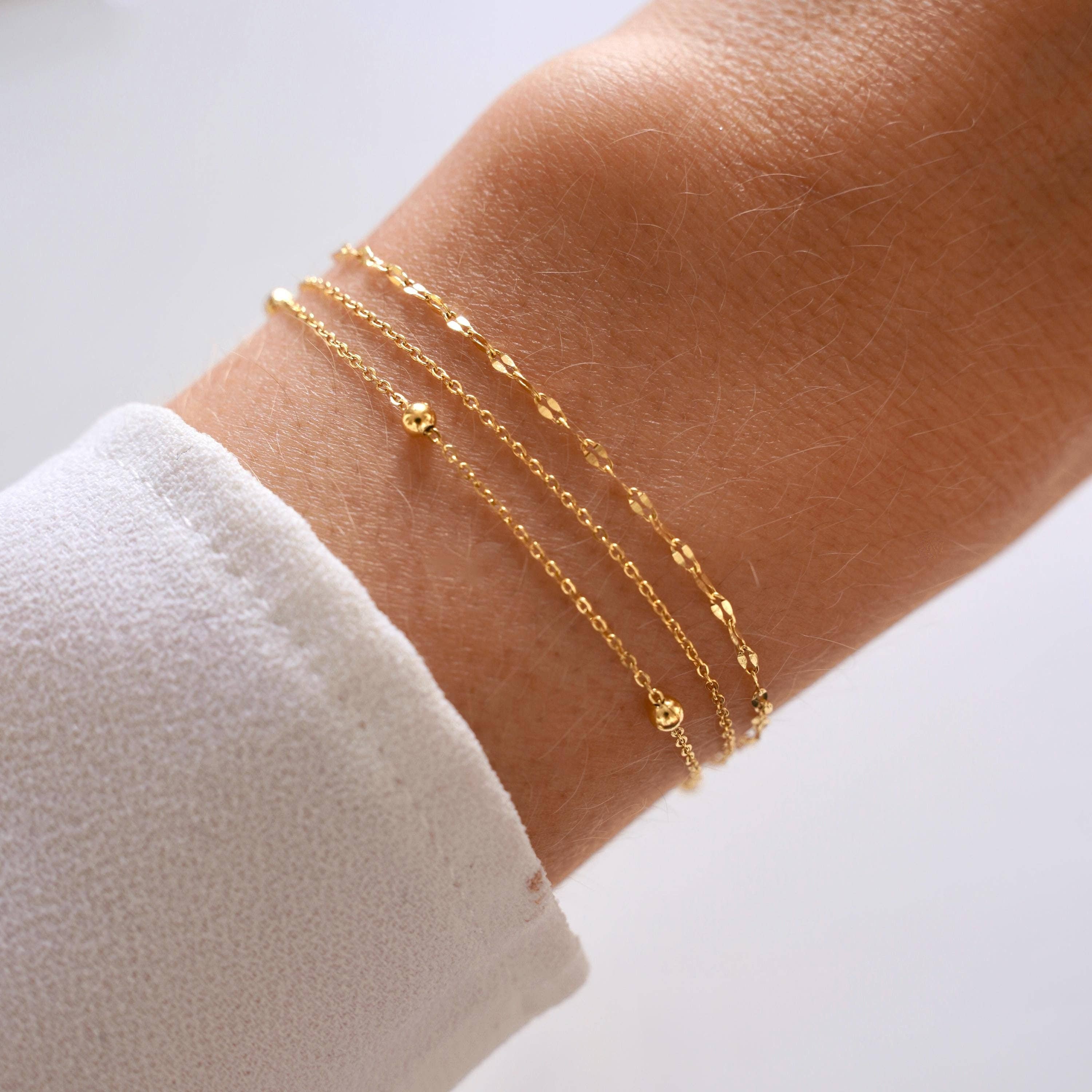 Elegant women's bracelet featuring three fine stainless steel chains with a 15.5 cm base length and 3 cm adjustable extender for a perfect wrist fit. Ideal for layering with other gold bracelets and makes a thoughtful gift. Packaged in a small jewellery pouch.