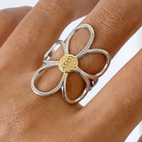 Sculptural floral ring featuring wide silver petals wrapped in radiant gold, creating a dimensional, nature-inspired design. Crafted from 18K gold and silver plated stainless steel in US size 7 (0.682" diameter). Hypoallergenic, water- and tarnish-resistant—an elegant blend of artistry and everyday wear.