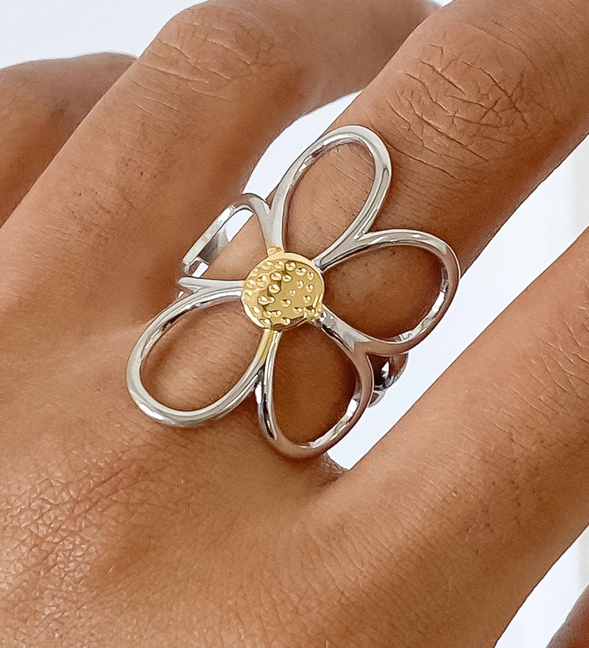 Sculptural floral ring featuring wide silver petals wrapped in radiant gold, creating a dimensional, nature-inspired design. Crafted from 18K gold and silver plated stainless steel in US size 7 (0.682" diameter). Hypoallergenic, water- and tarnish-resistant—an elegant blend of artistry and everyday wear.
