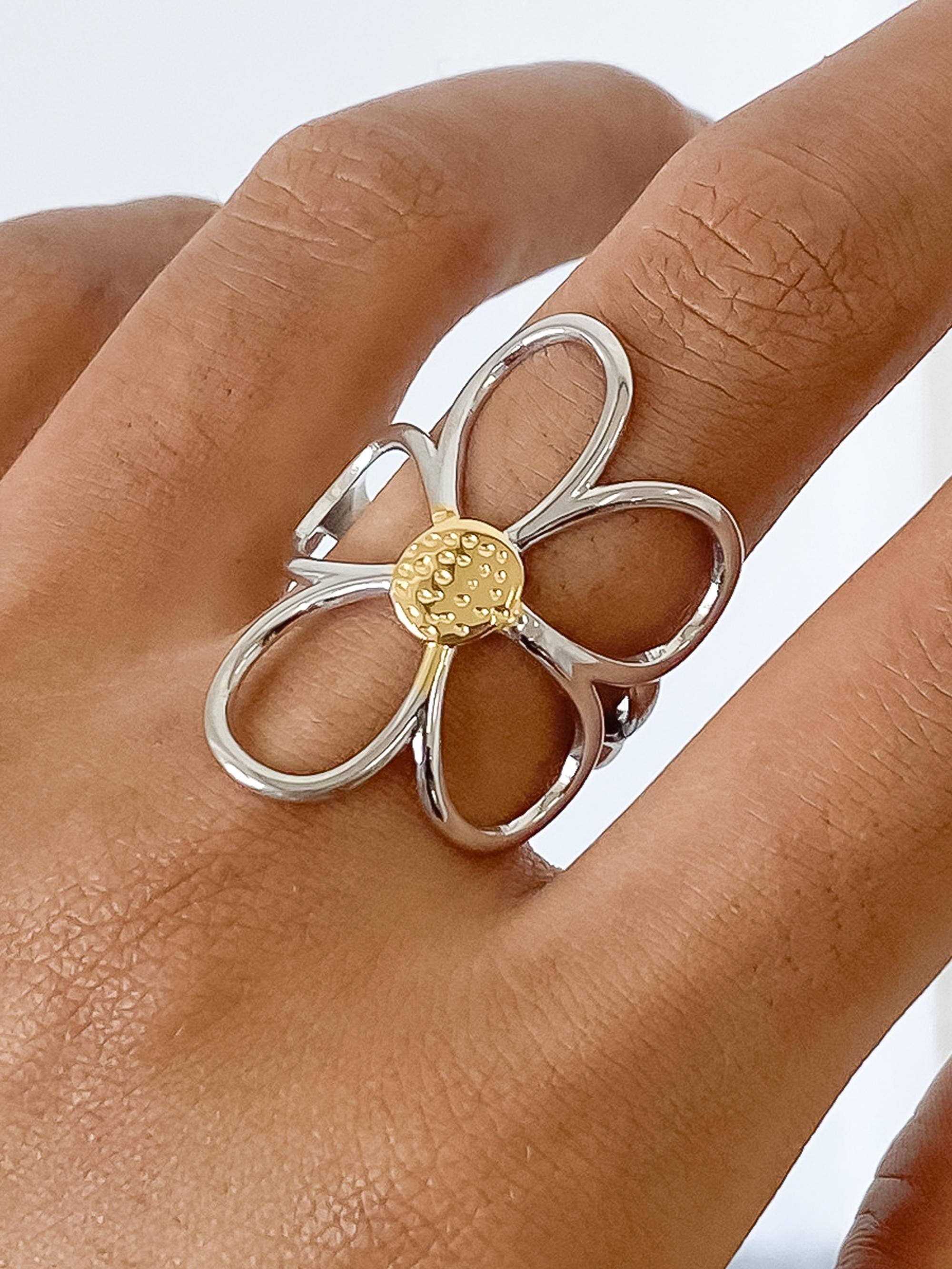 Sculptural floral ring featuring wide silver petals wrapped in radiant gold, creating a dimensional, nature-inspired design. Crafted from 18K gold and silver plated stainless steel in US size 7 (0.682" diameter). Hypoallergenic, water- and tarnish-resistant—an elegant blend of artistry and everyday wear.