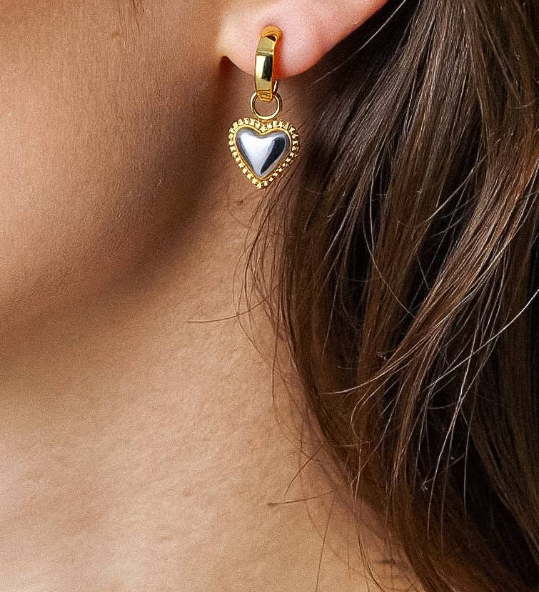 Sculptural heart-shaped earrings in a two-tone gold and silver finish, crafted from 18K gold-plated stainless steel. Measuring 2.82 × 1.30 cm, these hypoallergenic, water- and tarnish-resistant earrings bring a modern romantic touch to any look.