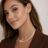 Woman wearing a brown blazer with a plain background